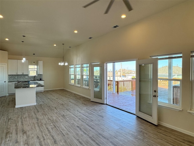 interior space featuring recessed lighting, light wood-style floors, visible vents, and ceiling fan with notable chandelier