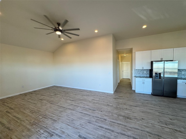 kitchen featuring open floor plan, lofted ceiling, a ceiling fan, wood finished floors, and stainless steel fridge with ice dispenser