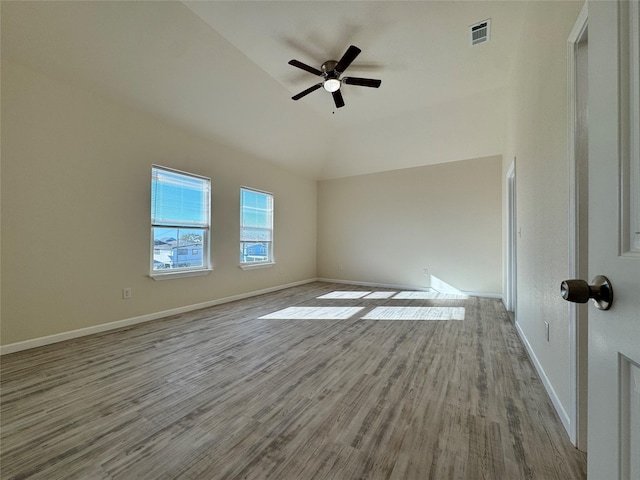 unfurnished room featuring lofted ceiling, wood finished floors, visible vents, baseboards, and ceiling fan