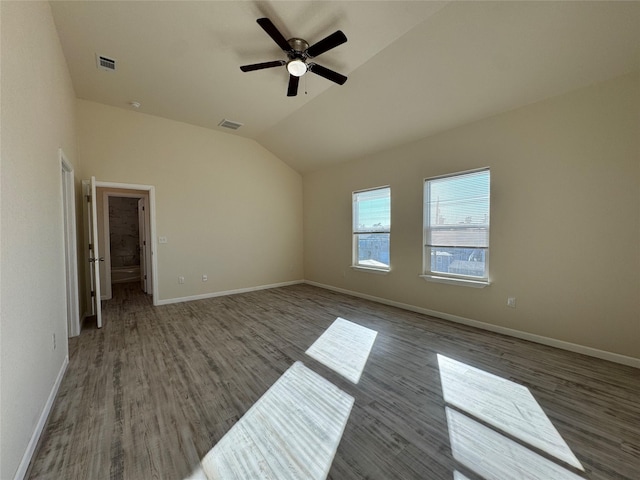 unfurnished bedroom featuring wood finished floors, visible vents, lofted ceiling, and baseboards