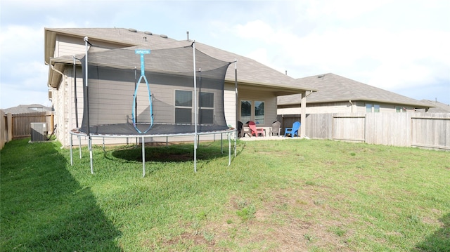 40607 Creekside Bluff Trl, Magnolia, TX 77354 - back of house featuring a trampoline, central air condition unit, and a patio