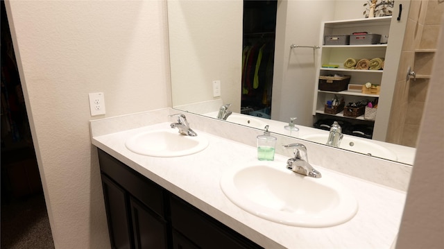 40607 Creekside Bluff Trl, Magnolia, TX 77354 - bathroom with double vanity, a textured wall, and a spacious closet