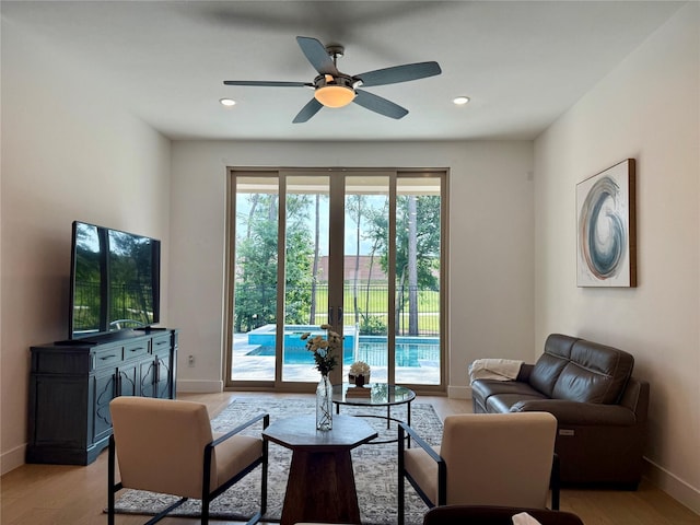 living room with recessed lighting, baseboards, ceiling fan, and light wood-type flooring