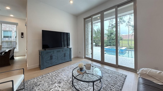 living room featuring light wood-style floors, recessed lighting, and baseboards