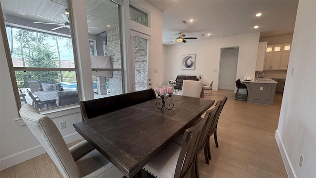 dining room featuring light wood-style floors, baseboards, and ceiling fan