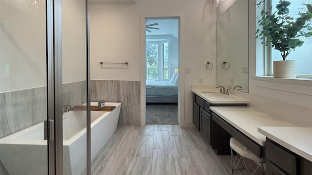 full bathroom with a freestanding bath, vanity, and connected bathroom