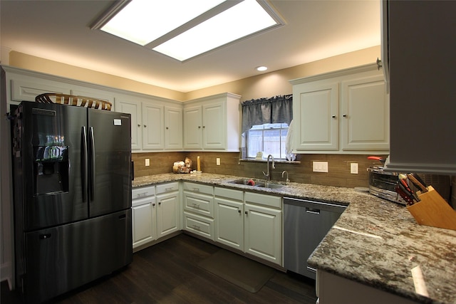 kitchen with stainless steel dishwasher, a sink, fridge with ice dispenser, white cabinetry, and dark wood-style floors