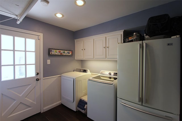 laundry room with dark wood finished floors, a wainscoted wall, washing machine and dryer, a wealth of natural light, and cabinet space
