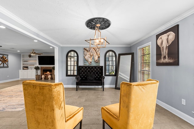 sitting room with built in shelves, crown molding, and baseboards