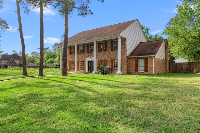 view of front of property featuring fence, a front lawn, and brick siding