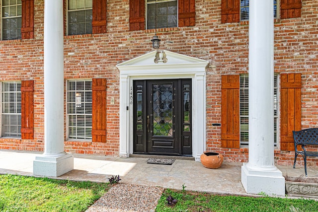entrance to property featuring brick siding