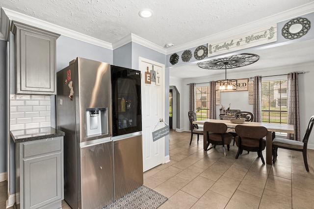 kitchen featuring a healthy amount of sunlight, light tile patterned floors, gray cabinetry, and stainless steel fridge with ice dispenser