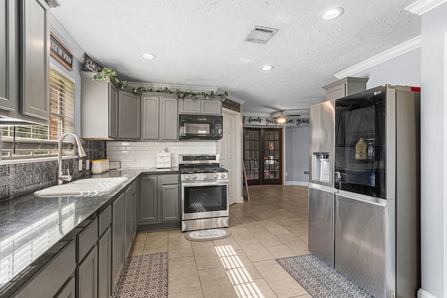 kitchen featuring visible vents, appliances with stainless steel finishes, gray cabinetry, and a sink