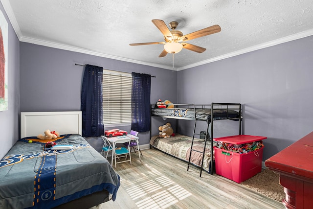 bedroom with wood finished floors, a textured ceiling, a ceiling fan, and ornamental molding