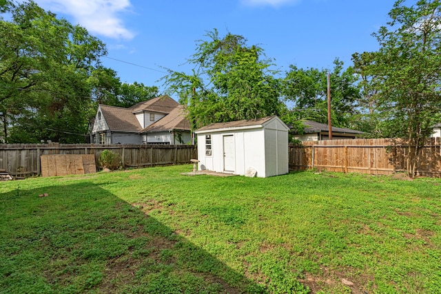 view of yard with a fenced backyard, an outdoor structure, and a storage shed