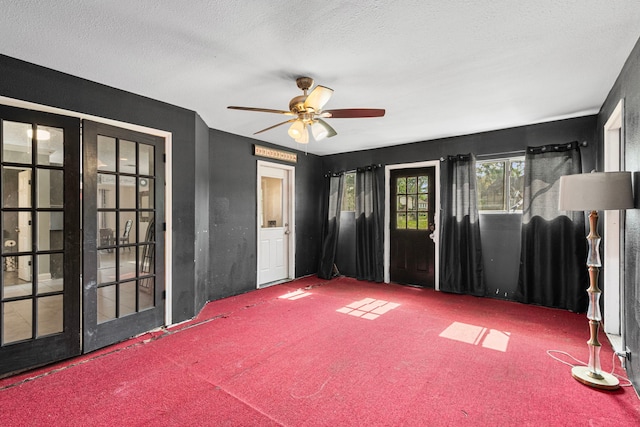 spare room with a ceiling fan, french doors, carpet floors, and a textured ceiling