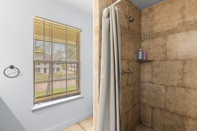 full bathroom featuring tile patterned flooring and tiled shower