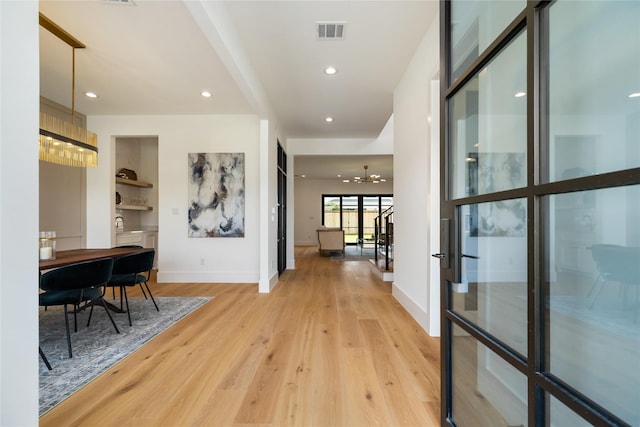 hallway with recessed lighting, visible vents, baseboards, a chandelier, and light wood-style flooring