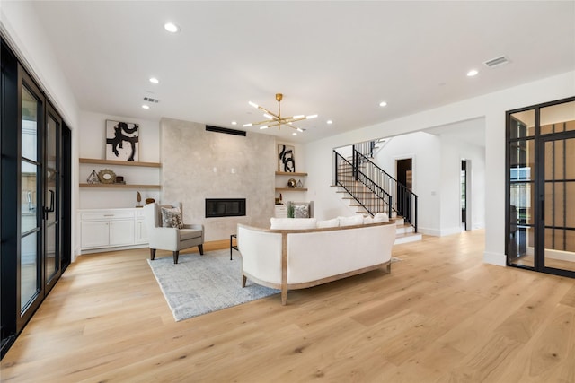 living room with recessed lighting, light wood-style floors, and stairway