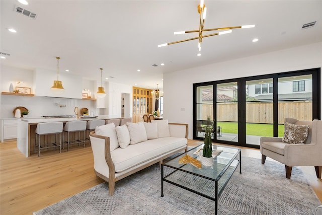 living area with recessed lighting, visible vents, and light wood-style flooring