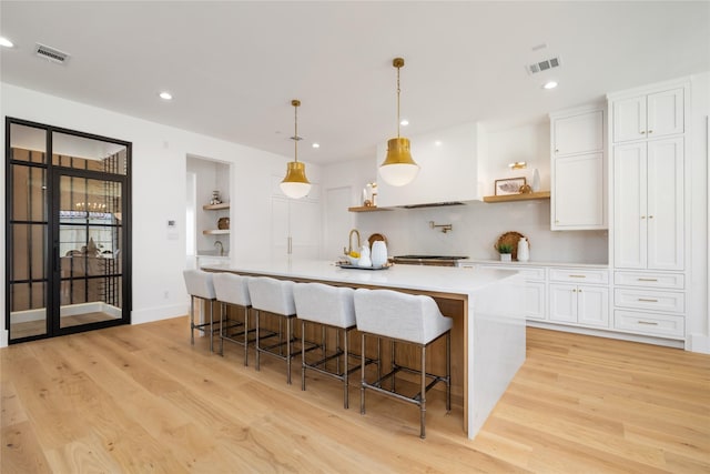 kitchen with open shelves, visible vents, and white cabinets