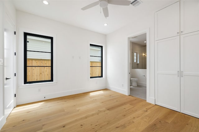 unfurnished bedroom with ensuite bath, baseboards, wood finished floors, and recessed lighting