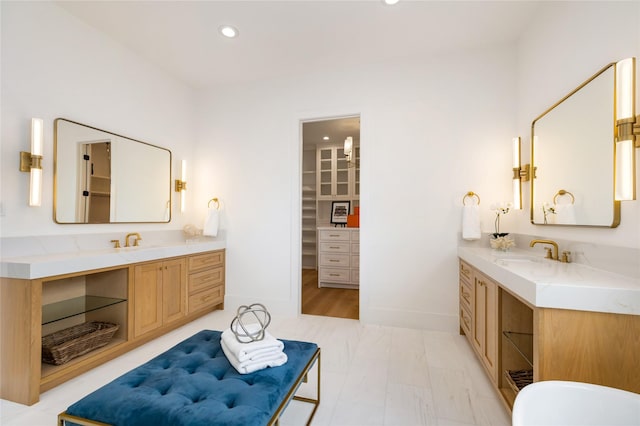 bathroom with two vanities, a sink, and recessed lighting