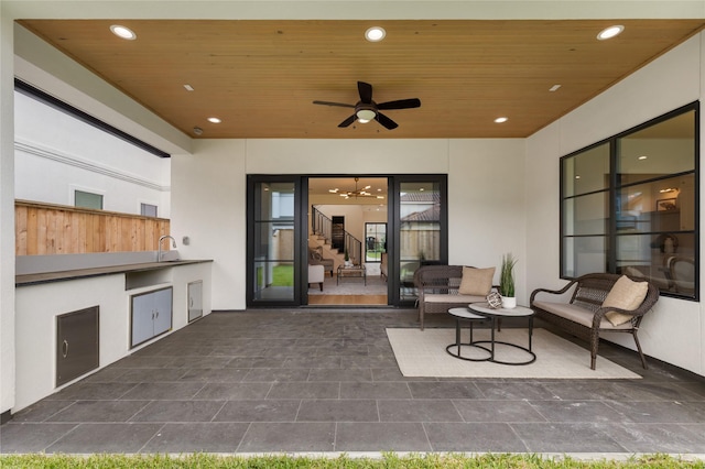 view of patio with an outdoor living space, a ceiling fan, and exterior kitchen