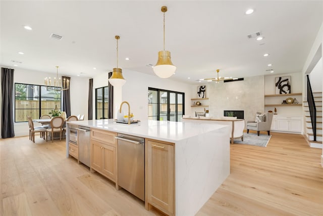 kitchen with light brown cabinets, an inviting chandelier, visible vents, and light wood-type flooring