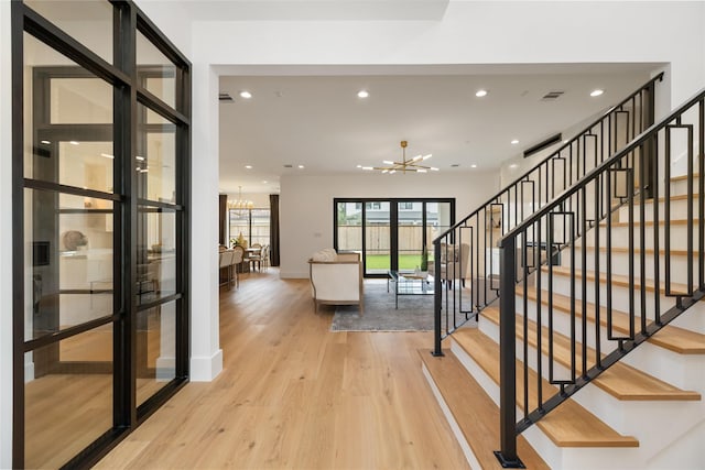 interior space with light wood finished floors, baseboards, recessed lighting, a notable chandelier, and visible vents