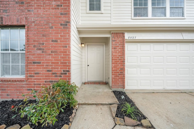 8027 Lavage Ln, Baytown, TX 77521 - view of exterior entry featuring brick siding and a garage