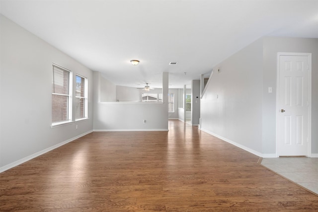 8027 Lavage Ln, Baytown, TX 77521 - unfurnished living room with plenty of natural light, a ceiling fan, wood finished floors, and baseboards