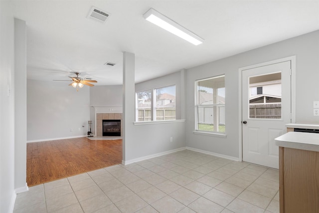 8027 Lavage Ln, Baytown, TX 77521 - unfurnished living room featuring light tile patterned flooring, a tile fireplace, visible vents, and ceiling fan