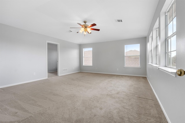 8027 Lavage Ln, Baytown, TX 77521 - unfurnished room with carpet floors, visible vents, a ceiling fan, and a healthy amount of sunlight