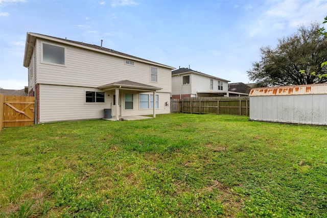 8027 Lavage Ln, Baytown, TX 77521 - rear view of house featuring a fenced backyard, an outdoor structure, a patio area, and a yard