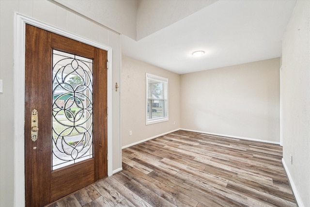 foyer featuring baseboards and wood finished floors