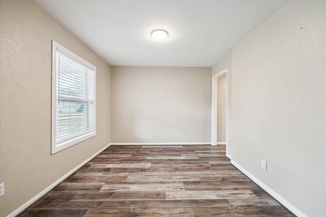 empty room featuring baseboards and wood finished floors