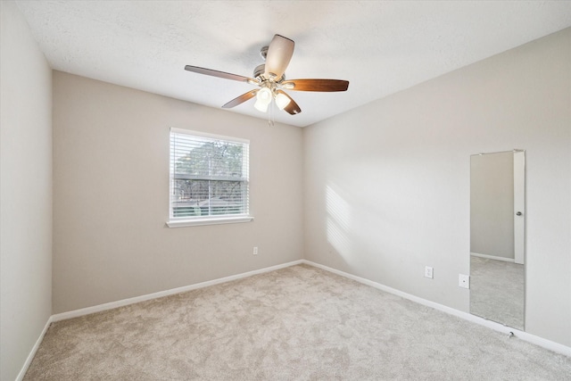 carpeted empty room with baseboards and ceiling fan