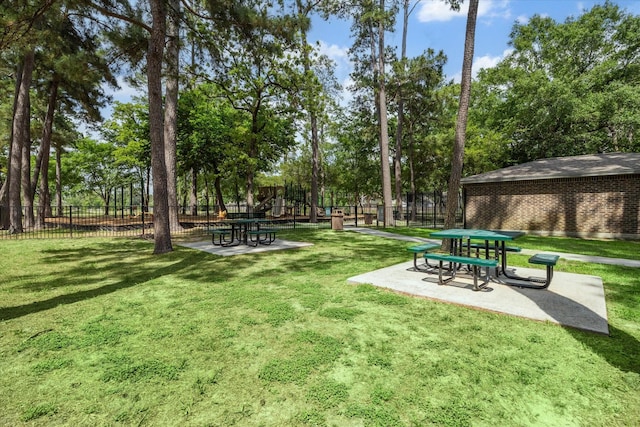 surrounding community featuring a lawn, fence, and a patio