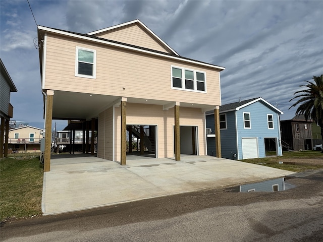 view of front of property with concrete driveway, a carport, stairs, and a garage