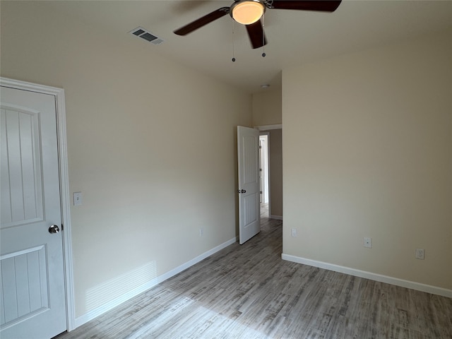 spare room featuring ceiling fan, baseboards, wood finished floors, and visible vents