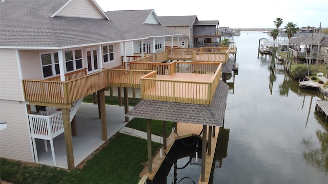 exterior space featuring a deck with water view and a patio area