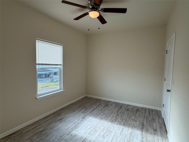 unfurnished room with baseboards, a ceiling fan, and wood finished floors