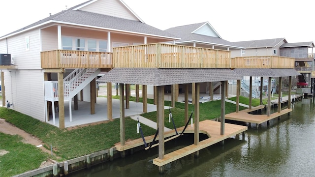 rear view of property featuring a patio area, central air condition unit, a lawn, roof with shingles, and stairs
