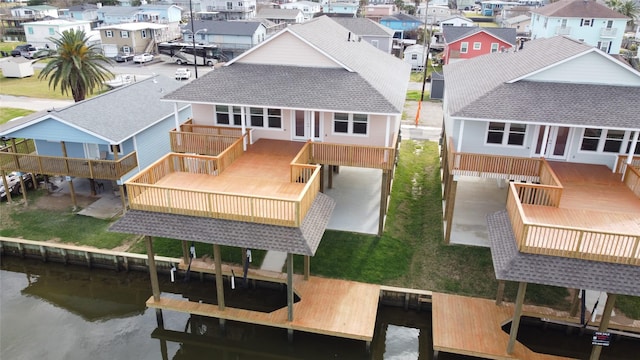 rear view of house with a deck with water view, a residential view, and french doors