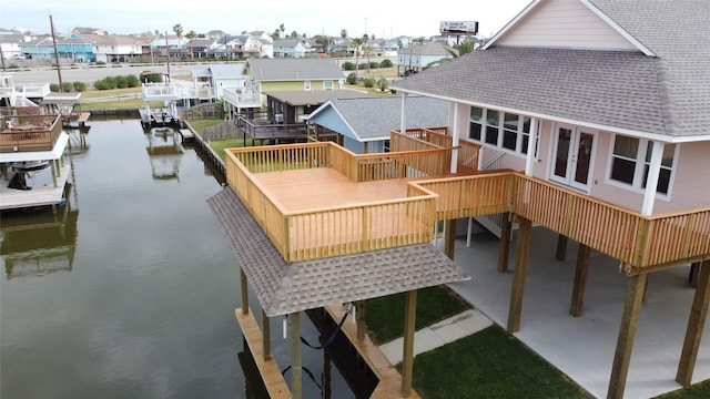 exterior space featuring a deck with water view, a residential view, and stairs