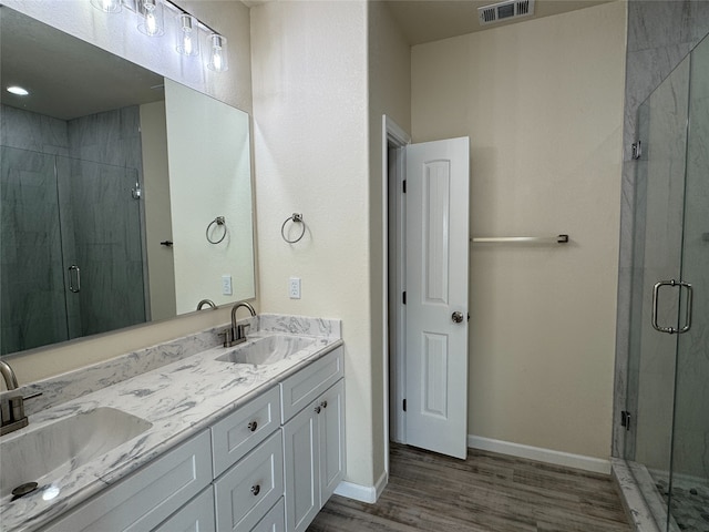 full bathroom with wood finished floors, visible vents, a sink, and a stall shower