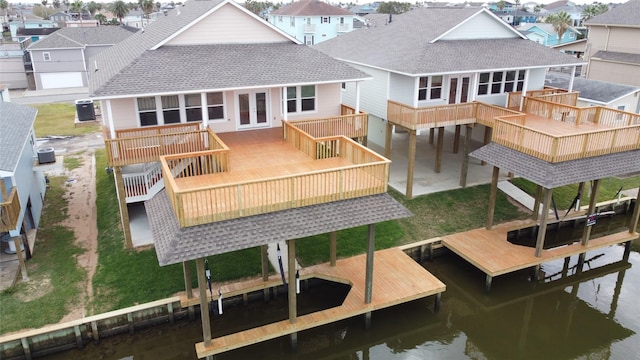 back of house with a deck with water view, a residential view, a shingled roof, and french doors
