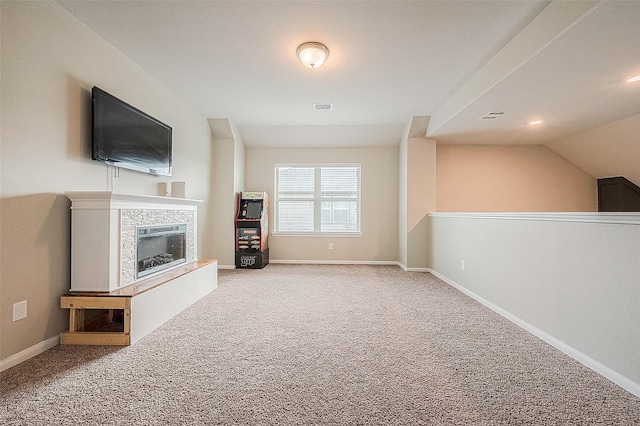 unfurnished living room with a glass covered fireplace, baseboards, carpet flooring, and visible vents