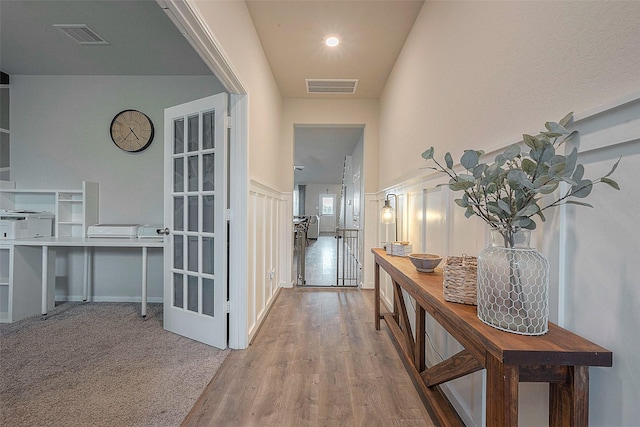 hallway featuring wood finished floors and visible vents